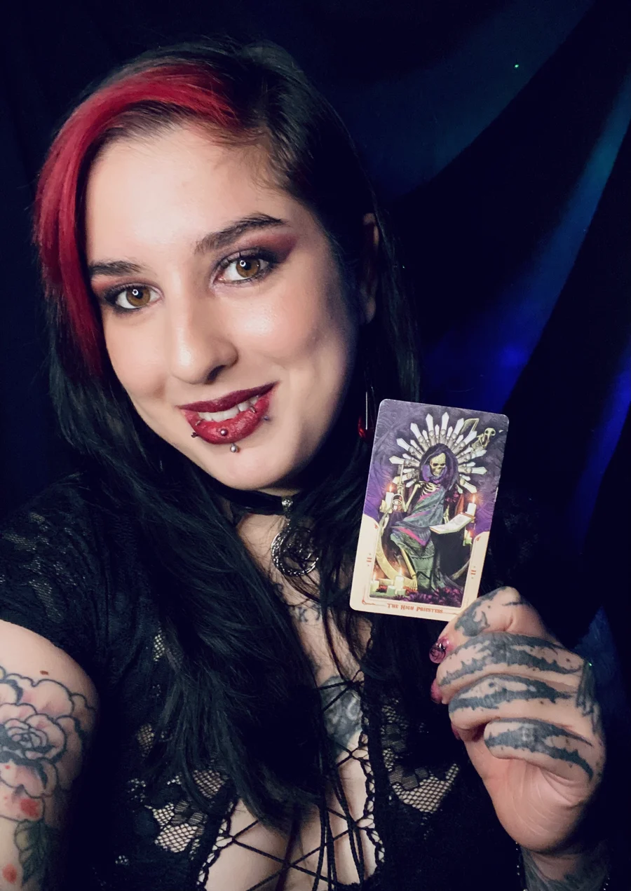 Lau, canalizadora y tarotista de Neptunoria Tarot, sosteniendo una carta de tarot